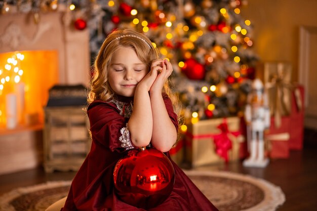 niña en un vestido festivo con un regalo