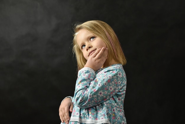 Niña en un vestido de pie y soñando