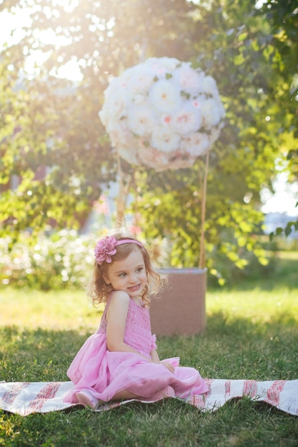 niña en vestido rosa divirtiéndose en el jardín