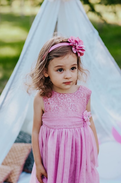 niña en vestido rosa divirtiéndose en el jardín