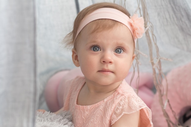una niña con un vestido rosa y un lazo rosa en la cabeza