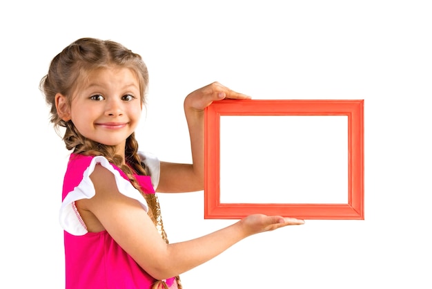 Una niña con un vestido rosa sostiene un marco de imagen.