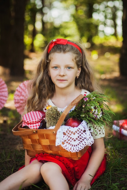 niña en un vestido sentado en el bosque