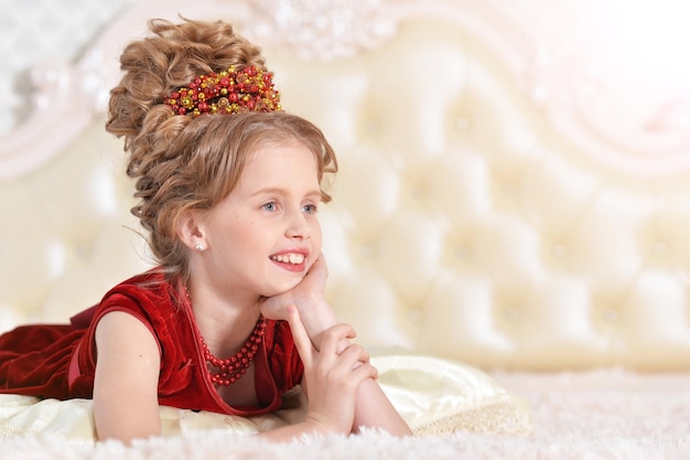 Niña en vestido de terciopelo rojo