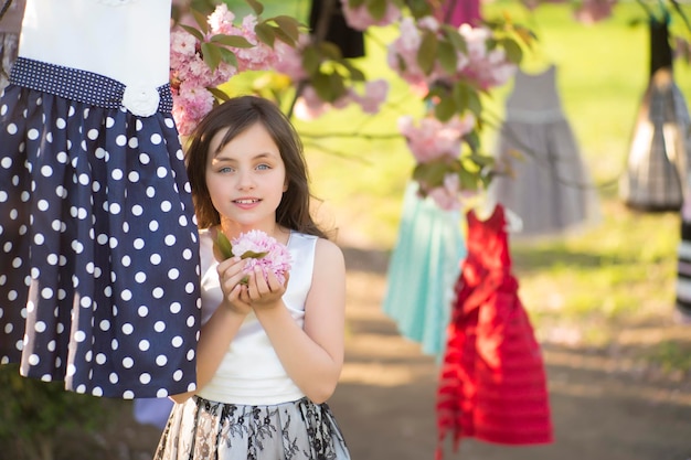 Niña entre vestidos en el árbol