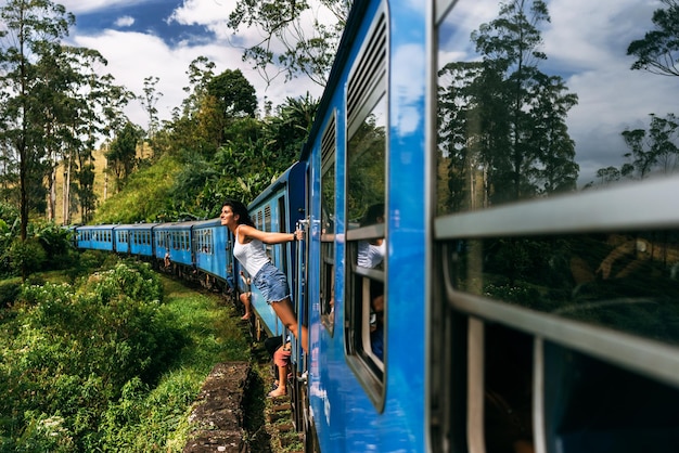 La niña viaja en tren a lugares hermosos. Hermosa chica viajando en tren entre montañas. Viaje en tren. Viajando a Asia. Trenes Sri Lanka. Transporte ferroviario. Ferrocarril. Transporte Asia