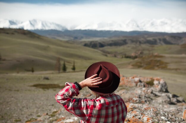 Niña viajera con sombrero en el fondo de las montañas