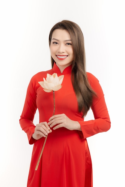 Niña vietnamita sosteniendo una flor de loto, el Ao dai es el traje tradicional de la mujer vietnamita