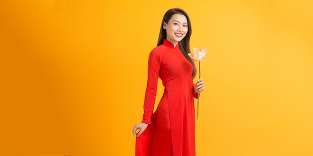 Niña vietnamita sosteniendo una flor de loto El vestido largo Ao dai vietnamita es un traje tradicional de mujer vietnamita