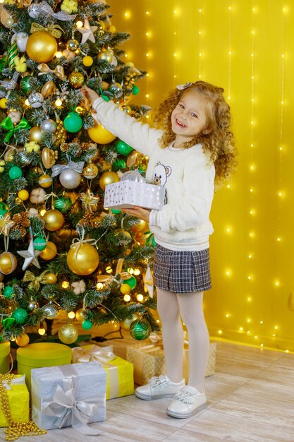 Niña viste un árbol de Navidad