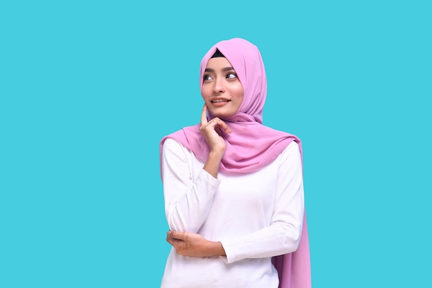 Niña vistiendo hijab rosa con las manos cruzadas mirando a la derecha modelo paquistaní indio