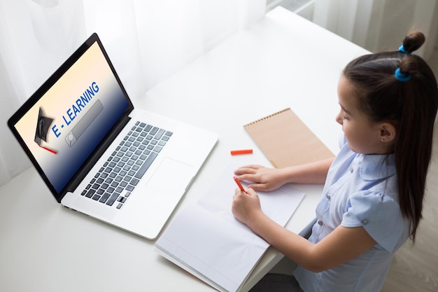 niñas alegremente lindas emocionados usando el trabajo escolar de aprendizaje por computadora. niño disfruta de e-learning en vacaciones en casa.