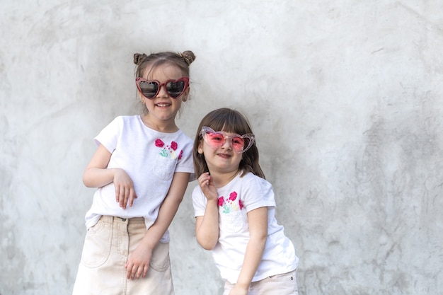 Niñas alegres en la pared con textura gris