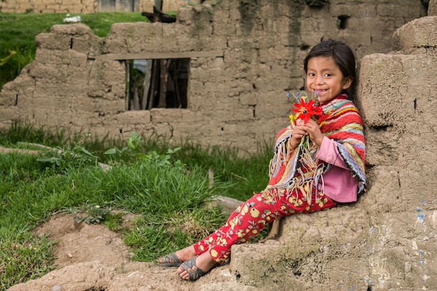 Niñas andinas peruanas haciendo tejidos y posando en su pueblo y casas con ropas de colores