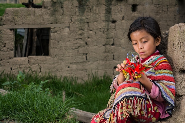 Niñas andinas peruanas haciendo tejidos y posando en su pueblo y casas con ropas de colores