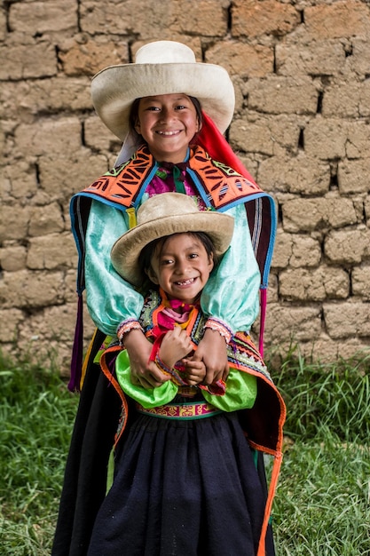 Niñas andinas peruanas haciendo tejidos y posando en su pueblo y casas con ropas de colores