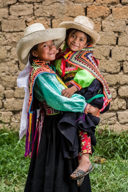 Niñas andinas peruanas haciendo tejidos y posando en su pueblo y casas con ropas de colores