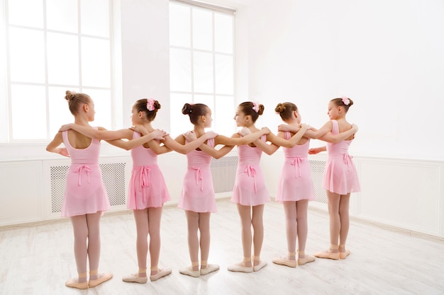 Foto niñas bailando ballet en estudio. danza coreografiada por un grupo de agraciadas bailarinas jóvenes practicando durante la clase