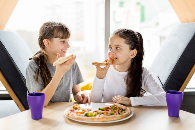 Foto niñas comiendo pizza