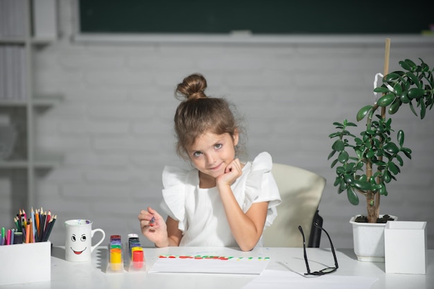 Niñas dibujando imágenes coloridas con lápices de colores en el aula de la escuela pintando niños divertidos