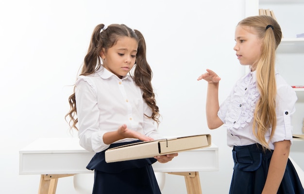 Las niñas discuten el problema el día escolar. Los niños trabajan en la solución de problemas en el aula.