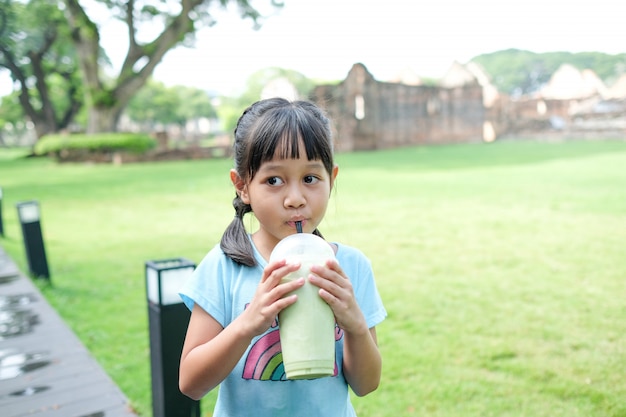 Foto las niñas disfrutan chupando bebidas de té verde.