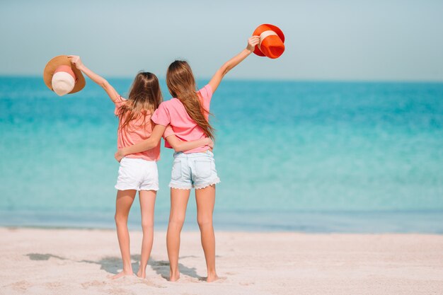 Las niñas divertidas y felices se divierten mucho en la playa tropical jugando juntas.