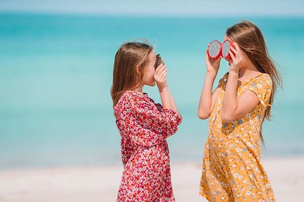 Las niñas divertidas y felices se divierten mucho en la playa tropical jugando juntas.