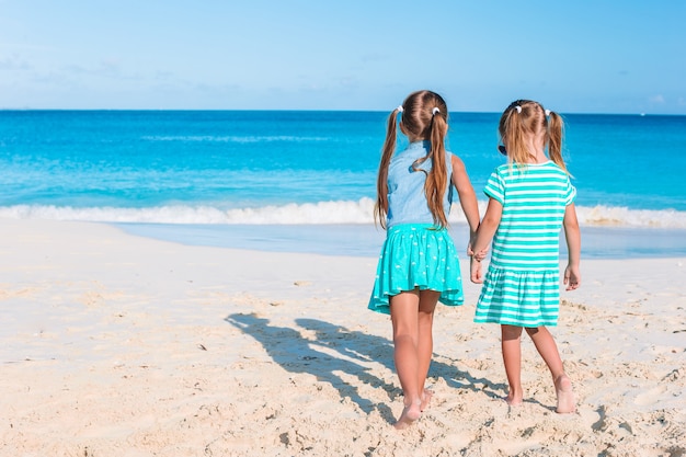 Las niñas divertidas y felices se divierten mucho en la playa tropical jugando juntas.