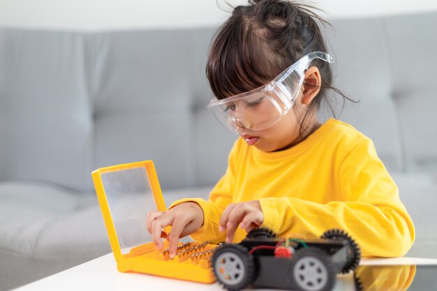 Niñas divirtiéndose en un coche robot de codificación de taller