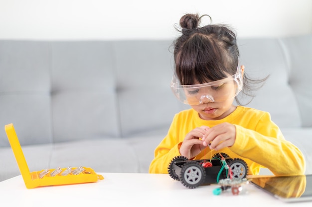 Niñas divirtiéndose en un coche robot de codificación de taller