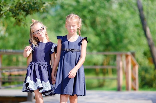 Niñas de la escuela adorables al aire libre en otoño