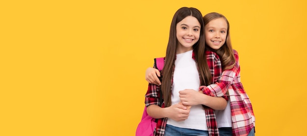 Foto niñas de la escuela amigas día del conocimiento concepto de educación niños con cabello largo sobre fondo amarillo