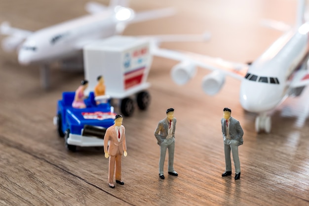 Las niñas están sentadas en el auto y los hombres están parados frente al avión.