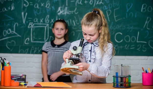 Las niñas estudian química en la escuela Lecciones de biología y química Teoría y práctica Observar reacciones químicas Escuela de educación formal Experimento educativo Regreso a la escuela Clases escolares