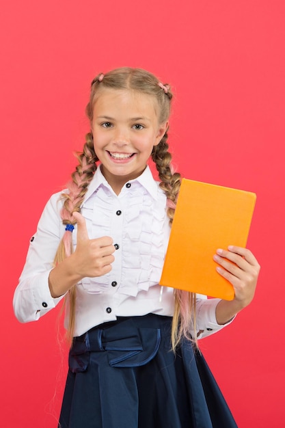 Niñas famosas por su obsesión con los artículos de papelería Uniforme escolar para niños Sostenga el libro Admirador de los artículos de papelería Colegiala muestra el bloc de notas Concepto de útiles escolares Papelería escolar Compre lindos artículos de papelería para divertirse estudiando