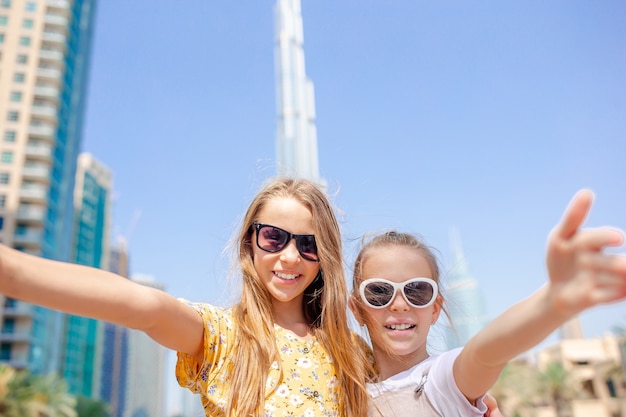 Niñas felices caminando en Dubai con rascacielos