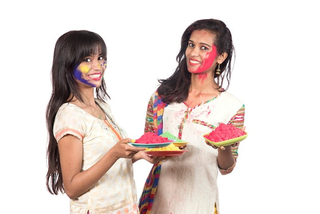 Niñas felices divirtiéndose con polvo de colores en el festival de colores Holi