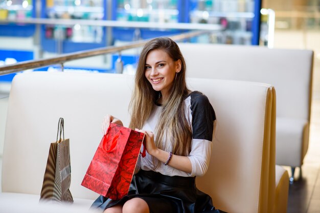 Las niñas felices están comprando en el centro comercial.