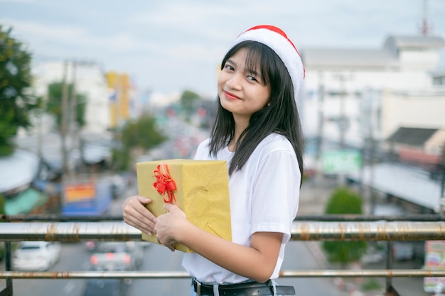 Las niñas felices usan sombrero de Navidad en el fondo de la vista de la ciudad.