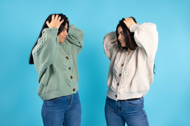 Las niñas gemelas sostienen sus dos manos en la cabeza y se miran asombradas