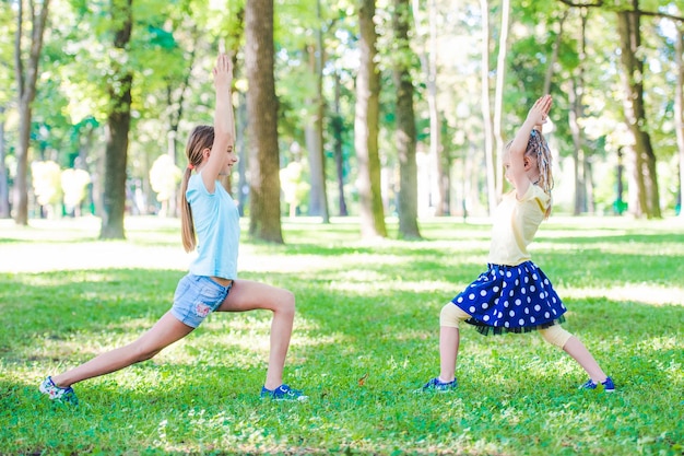 Foto las niñas hacen ejercicio en el parque del sol