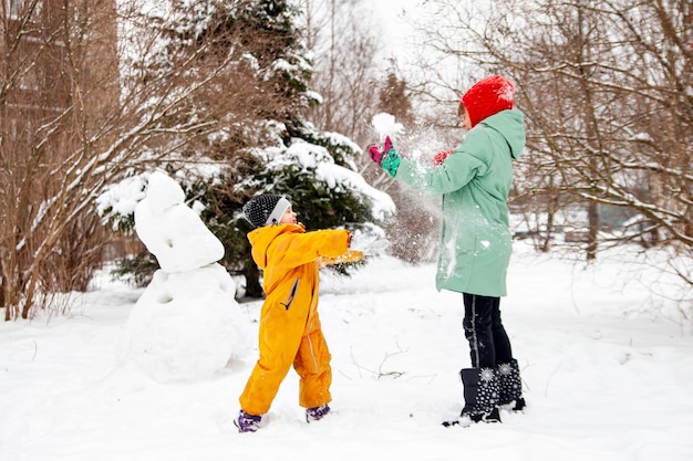 Las niñas juegan bolas de nieve en un día de invierno
