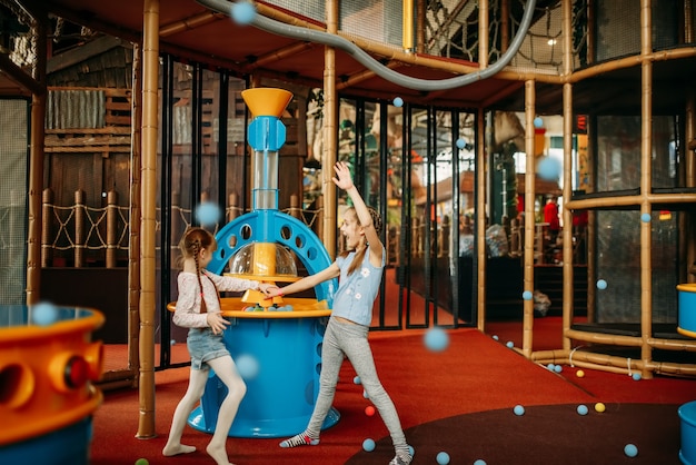 Las niñas juegan la máquina de pistola de aire, centro de juegos para niños