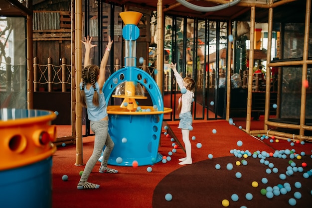 Las niñas juegan la máquina de pistola de aire, centro de juegos para niños