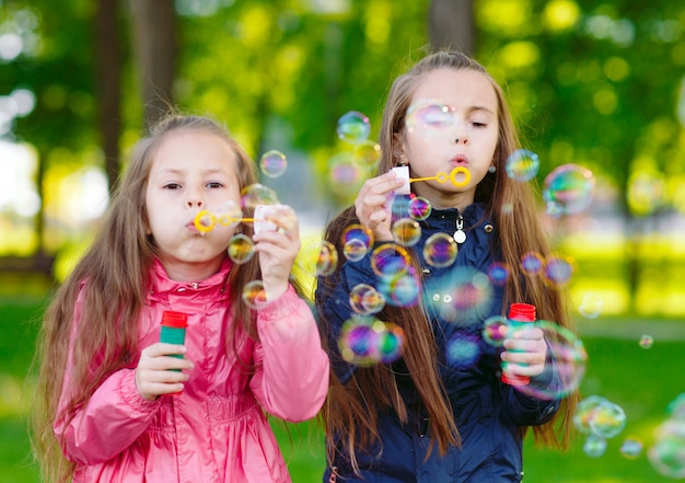 Las niñas juegan con pompas de jabón.