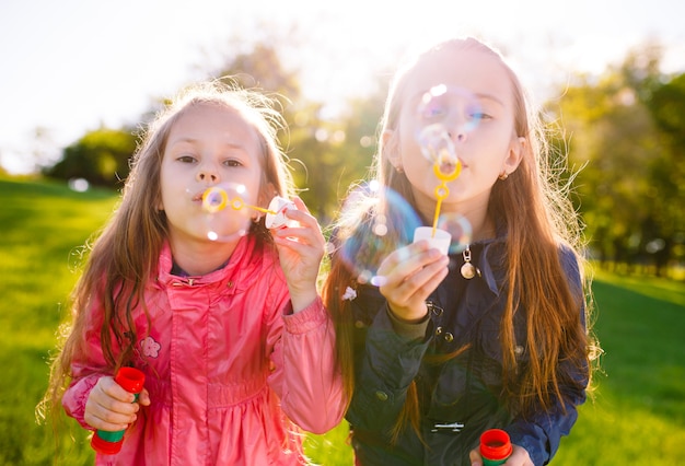 Las niñas juegan con pompas de jabón.