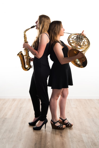 Niñas jugando instrumentos de viento