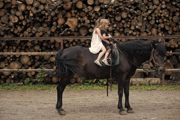 Las niñas montan a caballo en el día de verano