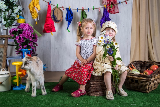 Niñas niño jugando con cabras en tierras de cultivo